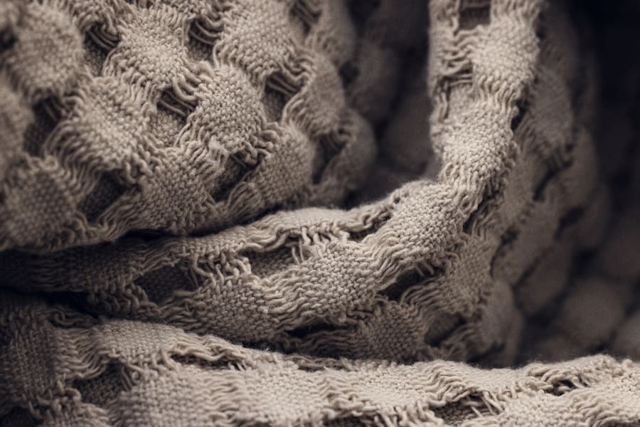 Close detail of folded oatmeal woven blankets
