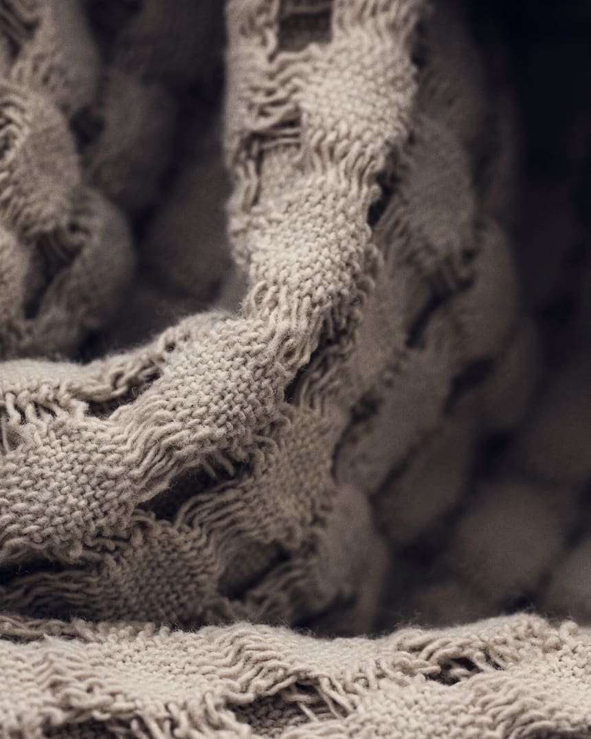 Folded woven blankets stacked on a shelf
