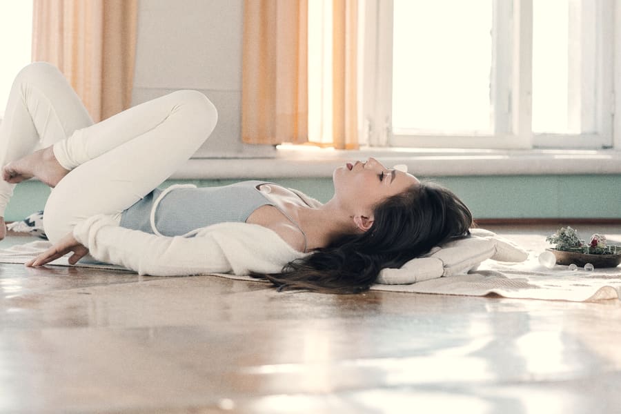 A practitioner resting in a supported reclining pose, held and unhurried