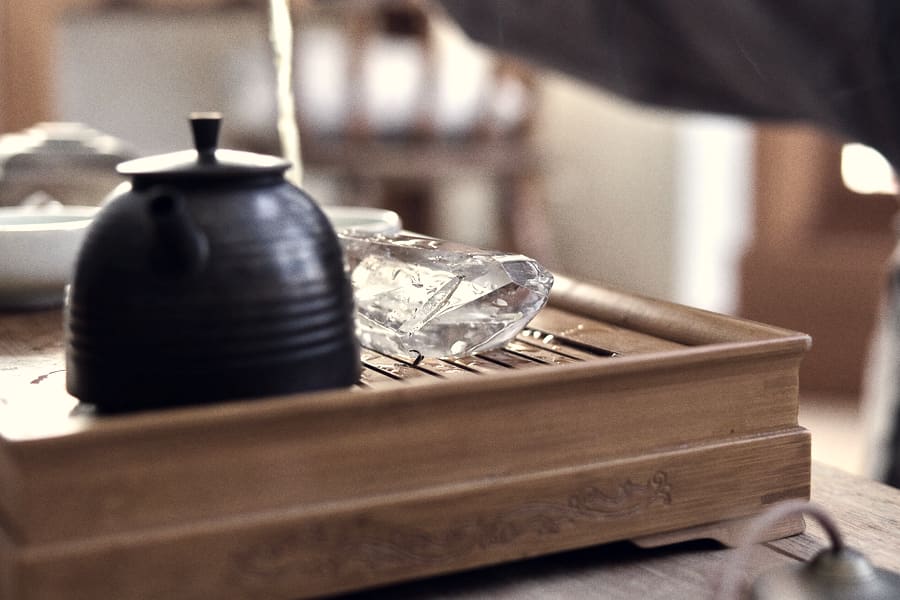 Tea being poured into a rustic clay cup